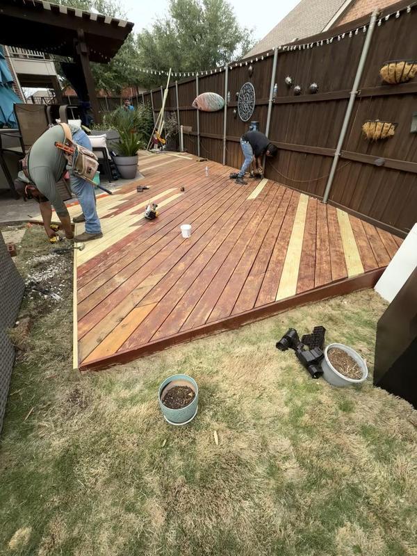 Wilson & Co Design Build crew staining a custom hardwood deck in Jacksonville, Florida